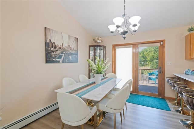 dining space with baseboard heating, hardwood / wood-style floors, a chandelier, and lofted ceiling