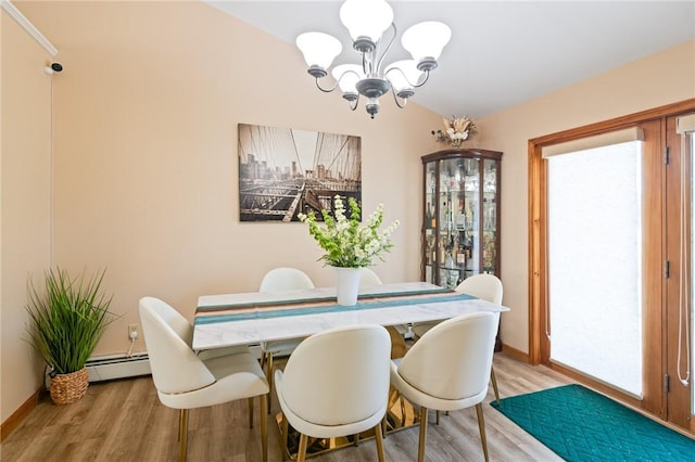 dining room featuring light hardwood / wood-style flooring, a baseboard heating unit, and an inviting chandelier