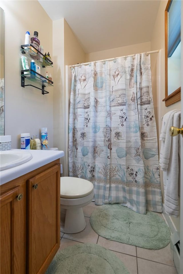 bathroom with tile patterned flooring, vanity, toilet, and walk in shower