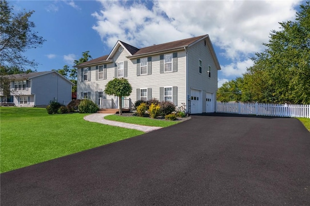 colonial-style house with a front yard and a garage