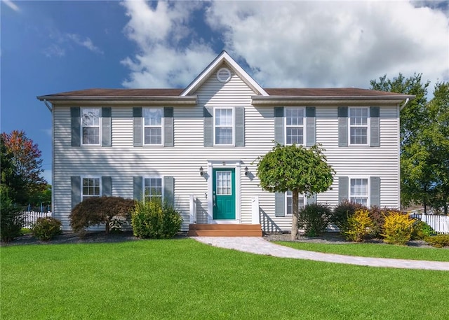 colonial-style house featuring a front yard