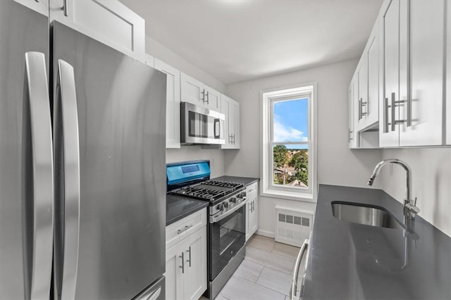 90 Union St Unit 6G, New Rochelle, NY 10805 - kitchen with radiator heating unit, white cabinetry, sink, and appliances with stainless steel finishes
