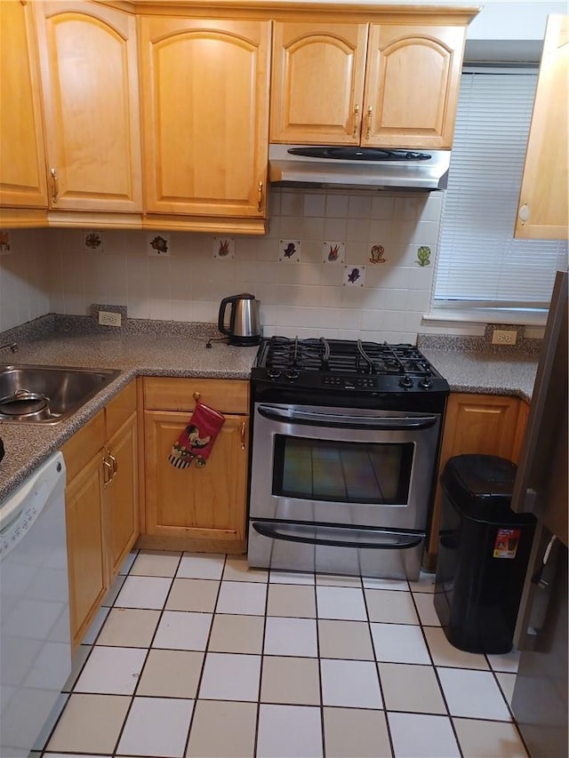 kitchen featuring dishwasher, stainless steel range with gas cooktop, sink, light tile patterned floors, and tasteful backsplash