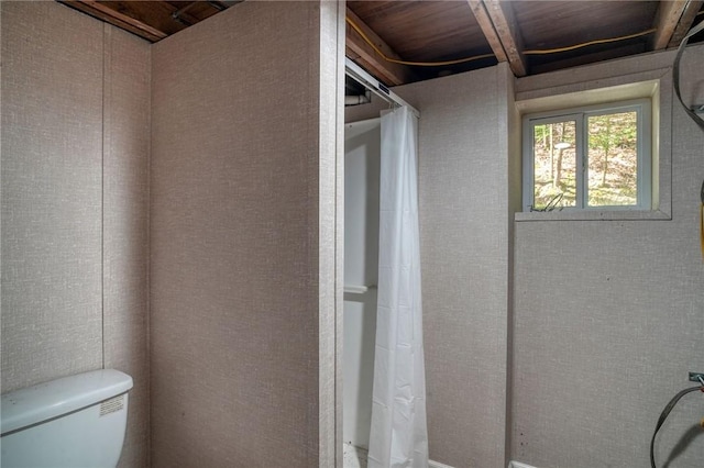 bathroom with toilet and a shower with shower curtain