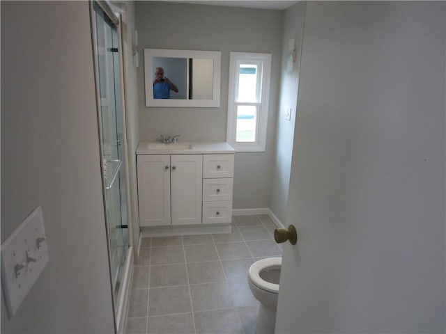 bathroom featuring toilet, vanity, tile patterned floors, and an enclosed shower