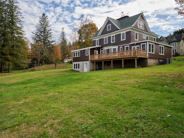 rear view of property with a deck, a yard, and central AC