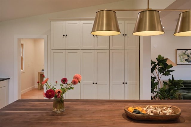 dining space featuring hardwood / wood-style flooring and vaulted ceiling