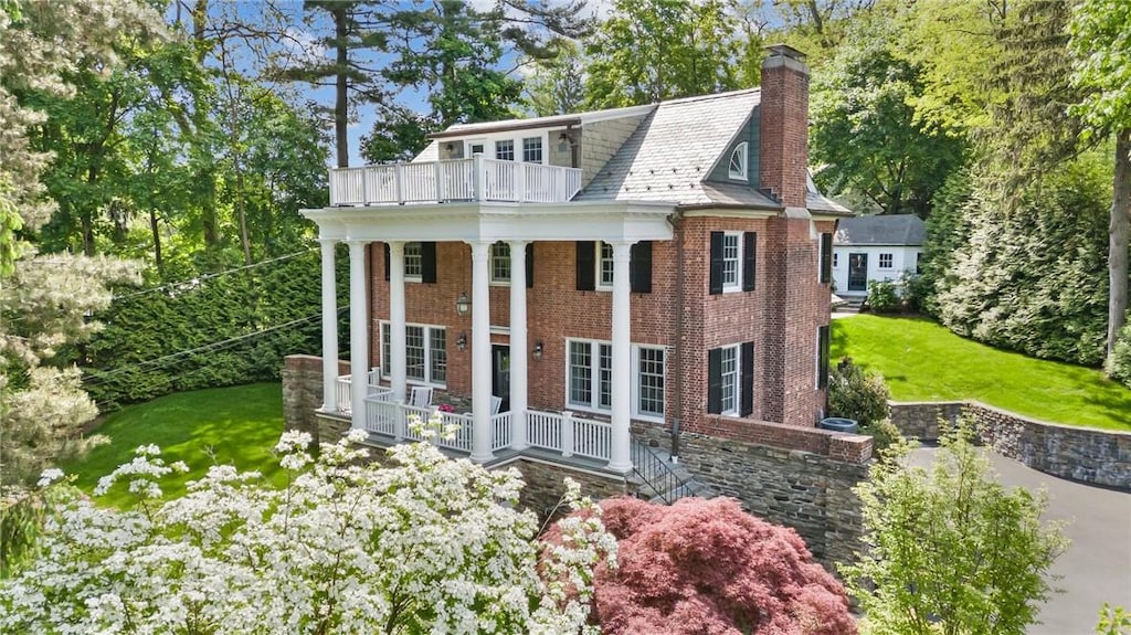 view of front of property with a balcony and a front yard