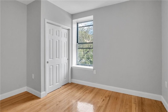 unfurnished bedroom with a closet and light hardwood / wood-style floors