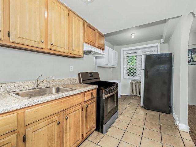 kitchen featuring light brown cabinets, sink, light tile patterned floors, radiator heating unit, and stainless steel appliances