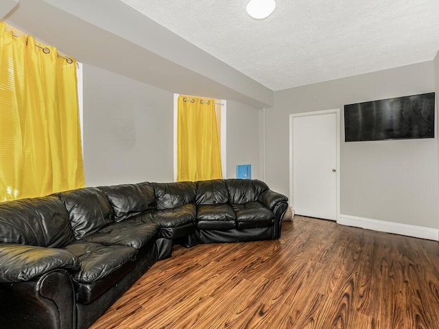 living room featuring dark hardwood / wood-style flooring and a textured ceiling