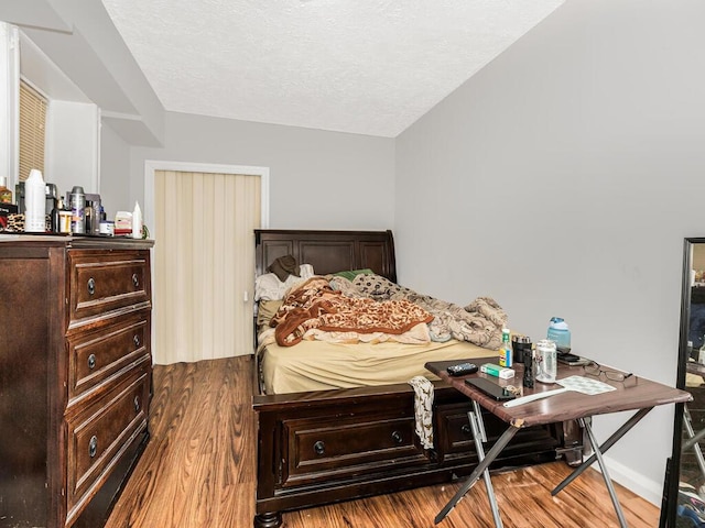 bedroom featuring a textured ceiling and hardwood / wood-style flooring