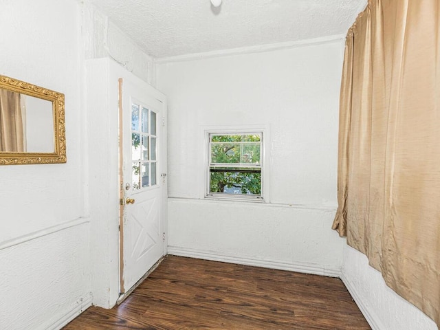 empty room featuring a textured ceiling and dark hardwood / wood-style floors