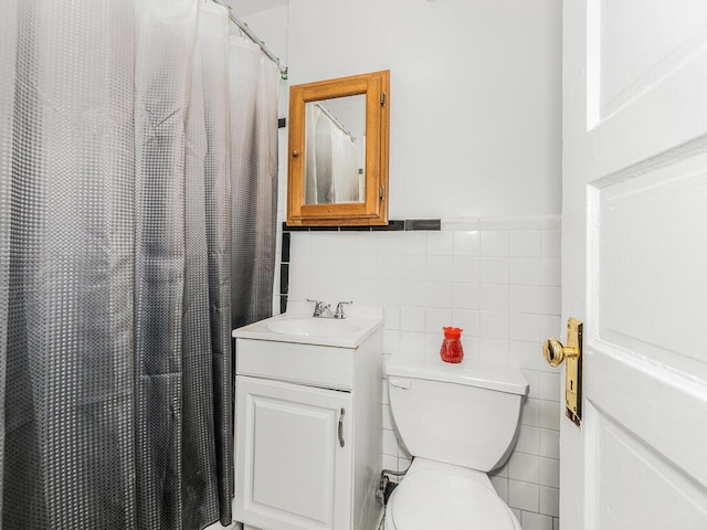 bathroom with walk in shower, vanity, toilet, and tile walls