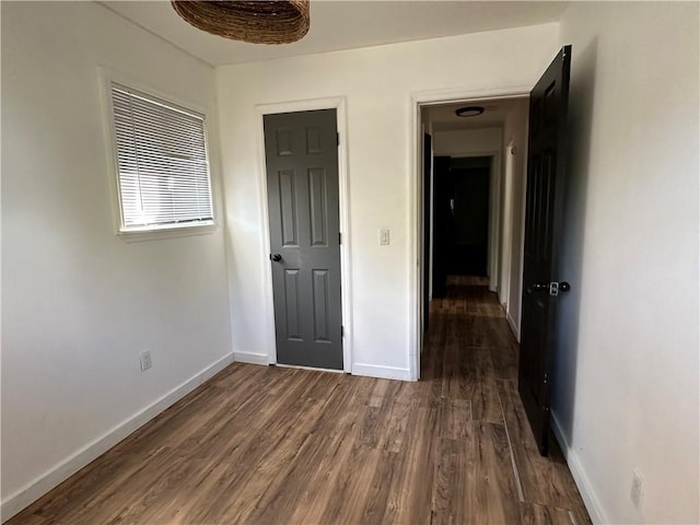 unfurnished bedroom with dark wood-style floors and baseboards