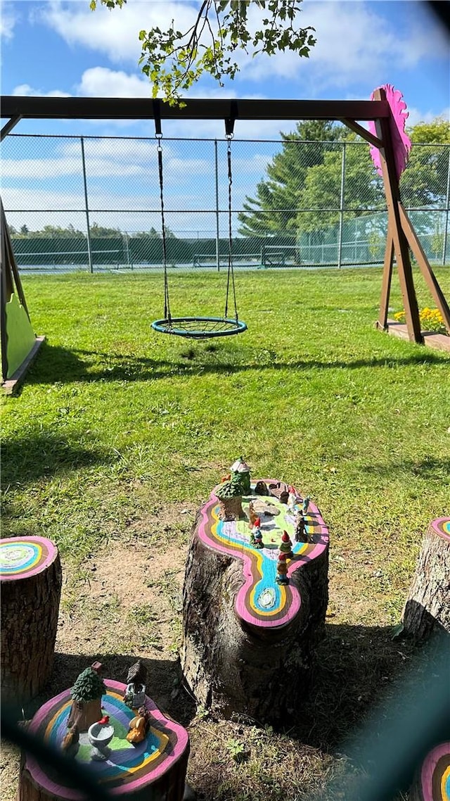 view of jungle gym with a lawn and fence