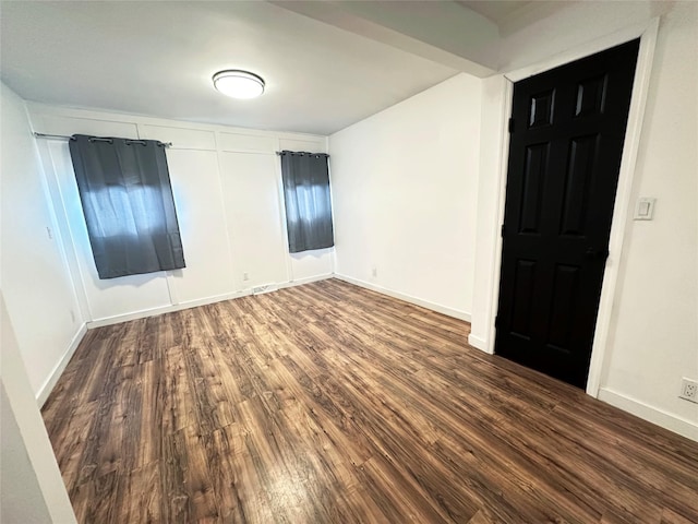 empty room featuring baseboards and wood finished floors