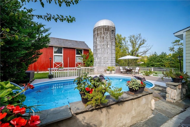 view of swimming pool with an outbuilding and a deck