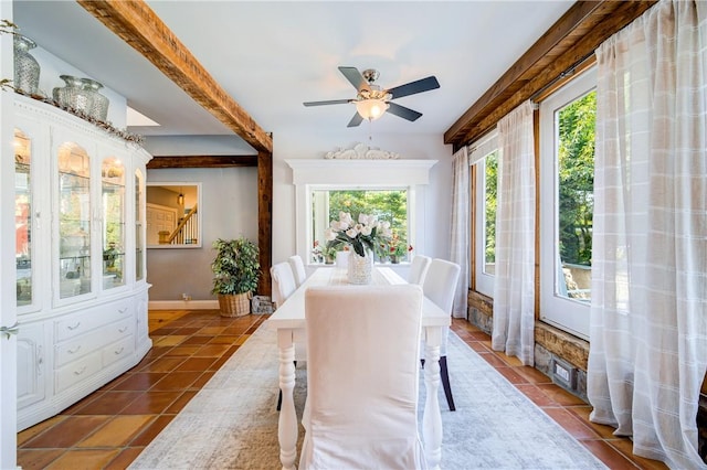 dining space featuring ceiling fan and dark tile patterned flooring