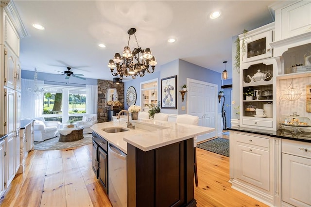 kitchen with pendant lighting, light wood-type flooring, stainless steel dishwasher, and sink