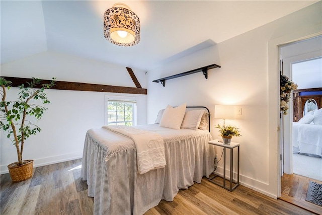 bedroom with wood-type flooring and vaulted ceiling