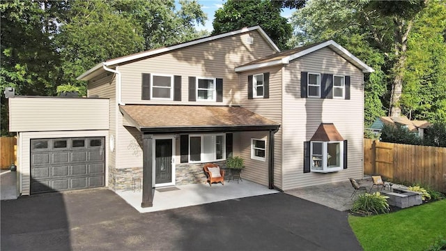 view of property with a garage and an outdoor fire pit