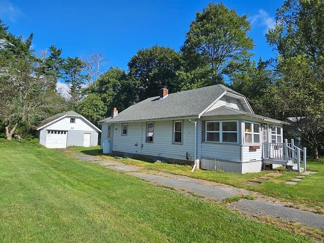 view of front of house with an outbuilding, a garage, and a front yard