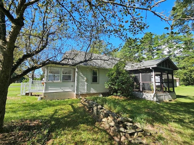 back of house featuring a wooden deck, a sunroom, and a yard