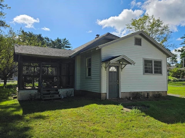 rear view of property with a sunroom and a yard