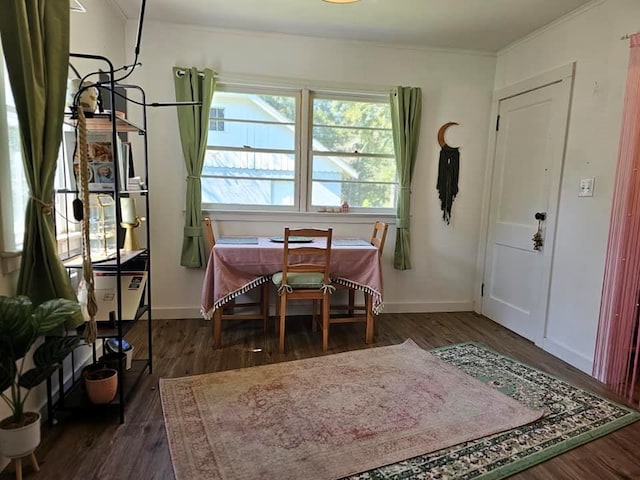 dining area featuring dark hardwood / wood-style floors and crown molding