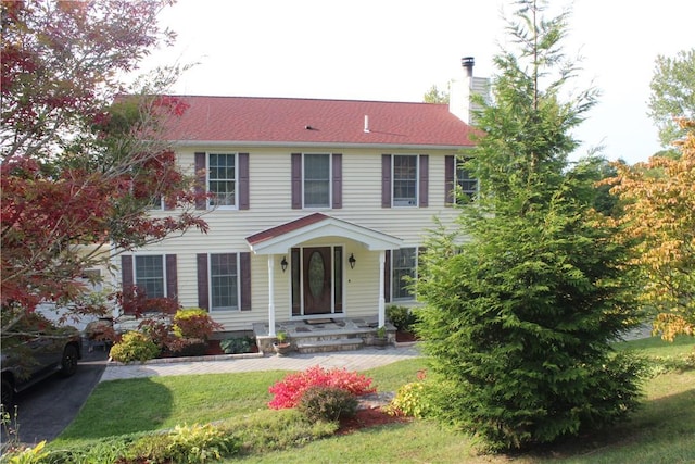 colonial-style house with a front lawn