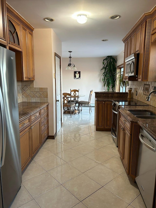 kitchen with sink, light tile patterned floors, pendant lighting, and appliances with stainless steel finishes