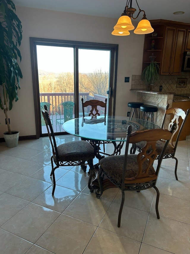 tiled dining room with a chandelier