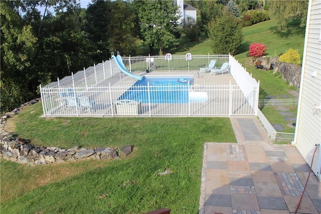 view of pool with a lawn, a patio area, and a water slide