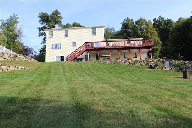 rear view of house with a wooden deck and a lawn