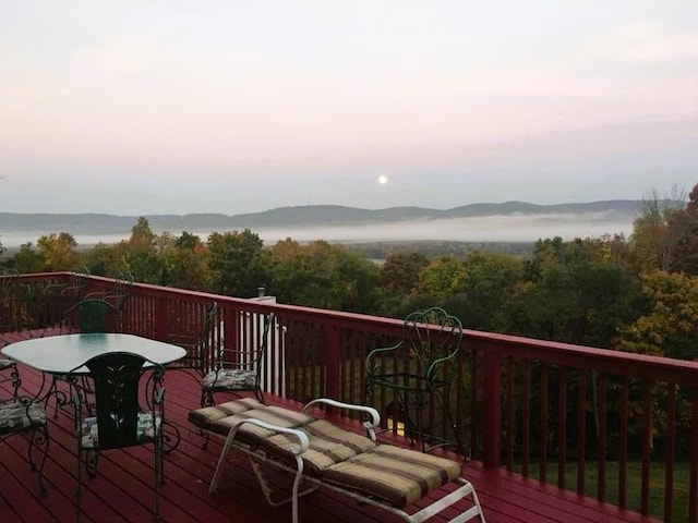 deck at dusk featuring a mountain view