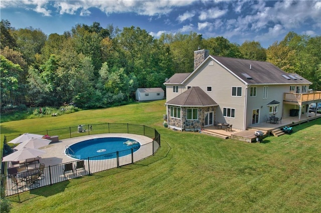 back of house featuring a lawn and a pool side deck