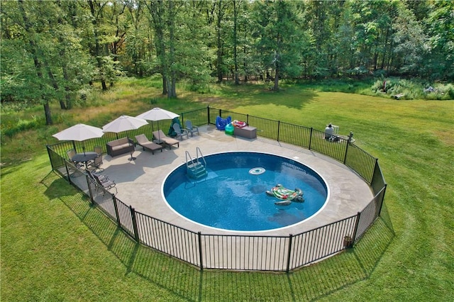 view of swimming pool featuring a patio area and a yard