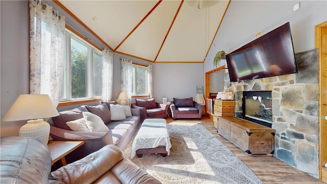 living room with a fireplace, light hardwood / wood-style flooring, and high vaulted ceiling