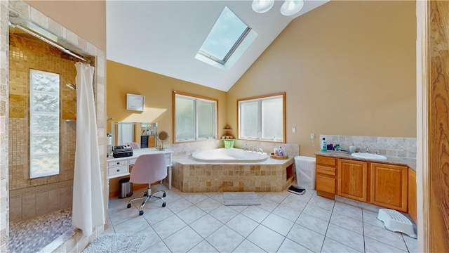 bathroom featuring tile patterned flooring, vanity, a skylight, and separate shower and tub