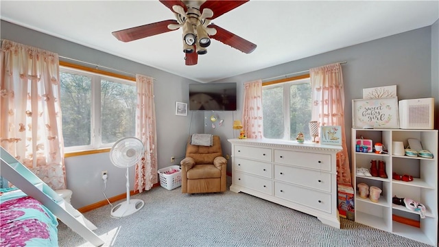 carpeted bedroom with ceiling fan and multiple windows