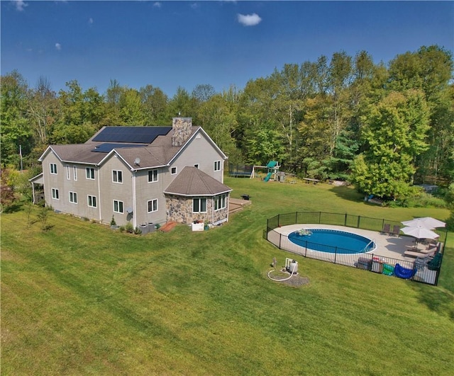 75 Monahan Rd, Port Jervis, NY 12771 - back of house featuring a playground, solar panels, a patio, a chimney, and a view of trees