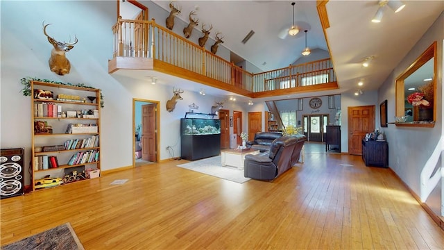 75 Monahan Rd, Port Jervis, NY 12771 - living room featuring hardwood / wood-style flooring, high vaulted ceiling, baseboards, and stairway