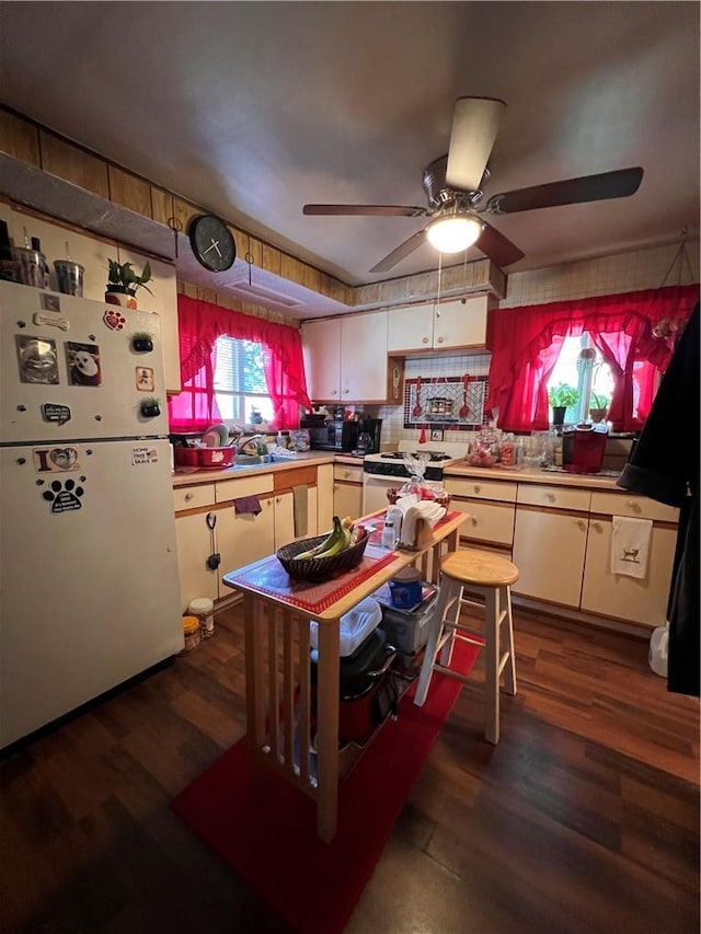 kitchen featuring dark hardwood / wood-style floors, ceiling fan, white appliances, and sink