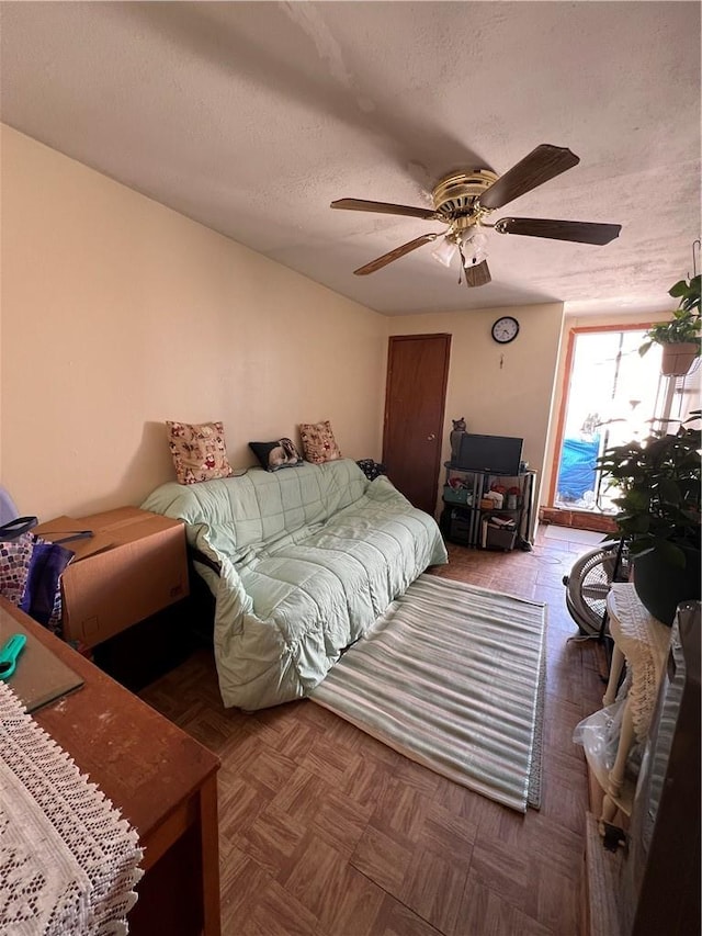 bedroom featuring ceiling fan and a textured ceiling