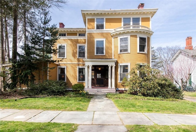 italianate-style house featuring a front lawn