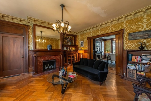 living room with a high end fireplace, a chandelier, and parquet floors