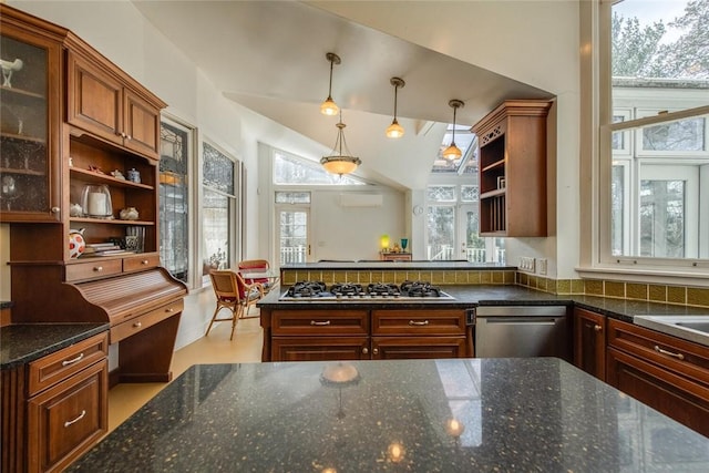 kitchen with pendant lighting, stainless steel appliances, a wealth of natural light, and dark stone counters