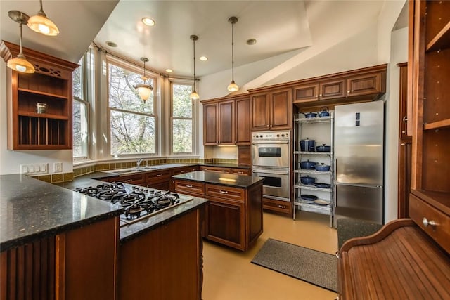 kitchen with sink, stainless steel appliances, dark stone counters, lofted ceiling, and decorative light fixtures