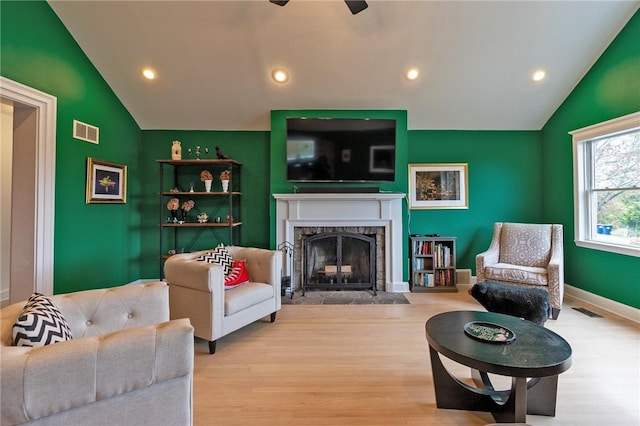 living room with light hardwood / wood-style flooring, ceiling fan, and lofted ceiling